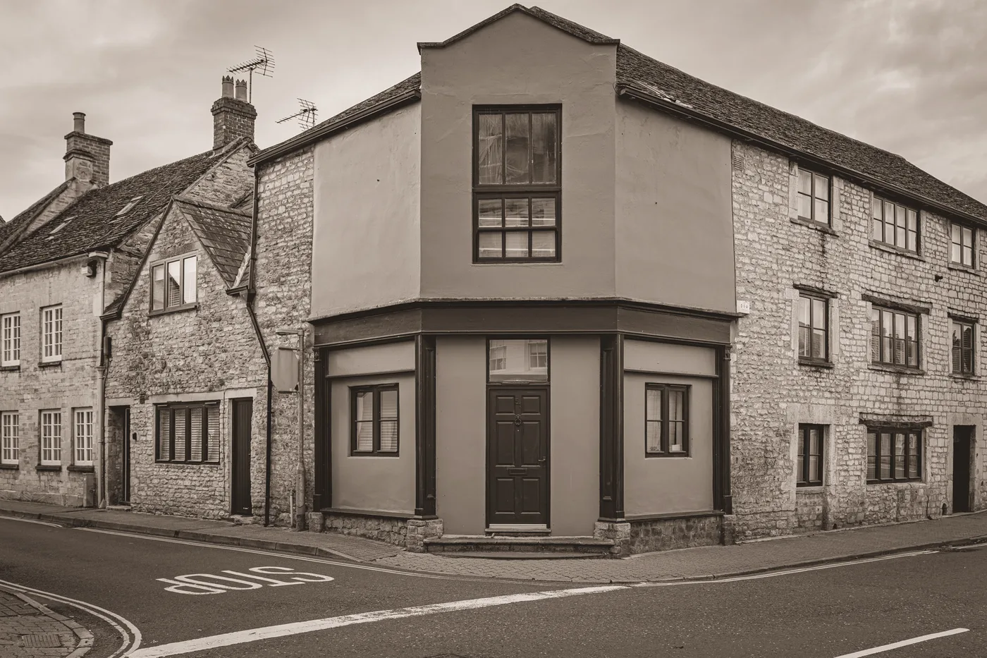 A stone corner house at a junction, graded at a fifth of full colour